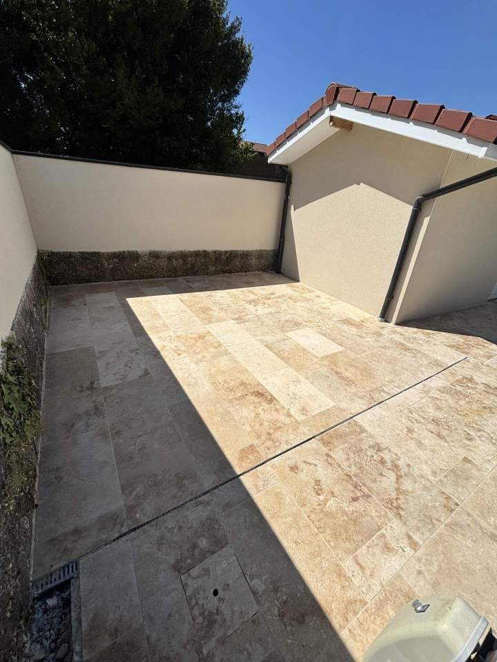 Aménagement d’une terrasse extérieure en carrelage effet travertin à Miribel