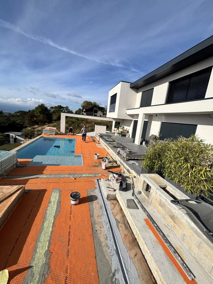 Pose d’une natte d’étanchéité autour d’une piscine avant la pose du carrelage. Préparation soignée du support et traitement des zones sensibles afin d’assurer une protection durable de la terrasse et de la plage de piscine.